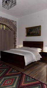 a bedroom with a large bed and a rug at Vila Janko in Voskopojë +19 photos