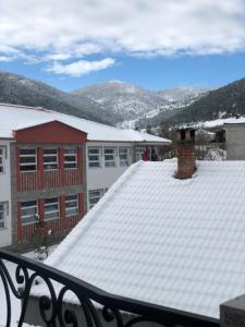 a snow covered roof of a building with mountains in the background at Vila Janko in Voskopojë