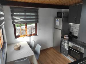 a small kitchen with a table and a refrigerator at Casa Terra & Mar in Urzelina