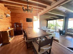 a dining room with a large wooden table and chairs at Casa a orilla de Lago Panguipulli in Panguipulli