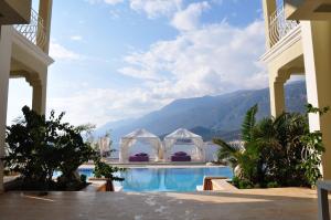 a pool at a resort with mountains in the background at Lukka Exclusive Hotel – Adult Only +12 in Kaş