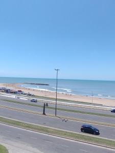 a car driving down a highway next to the beach at Colibri MDQ in Mar del Plata