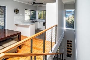 una cocina y una escalera en una casa con paredes blancas en Aspect 2 8 Poley Cow, en Jindabyne