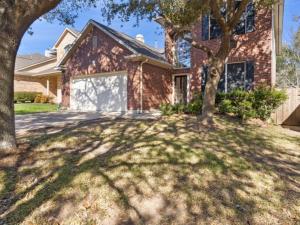 ein Backsteinhaus mit einem Baum davor in der Unterkunft Cozy Sunterro Serenity in North Austin Pet Friendly in Austin