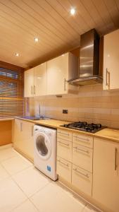 eine Küche mit einer Waschmaschine in der Unterkunft Urban Luxe Stays - Purbrook Bridge in London