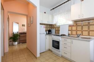 a kitchen with white cabinets and a sink at Apartments Kate in Malinska