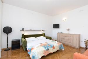 a bedroom with a bed and a tv on the wall at Apartments Kate in Malinska +20 photos