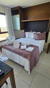 a bedroom with a large bed with towels on it at VG Sun Cumbuco by TP Flats in Cumbuco