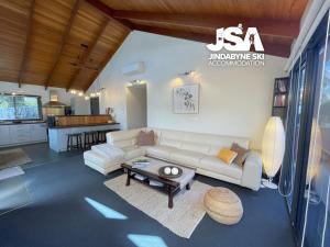 a living room with a couch and a table at Pine Peak in Jindabyne