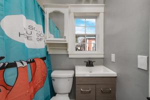 Un baño con inodoro, lavabo y ventana. en Comfy Studio with King Bed & Full Kitchen - Near Attractions, en Houston