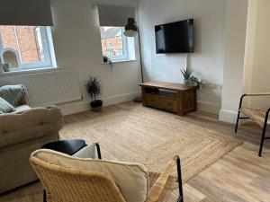 a living room with a couch and a tv at The Old Band Accommodation 1 kingsize bed and 1 Sofa Bed available in Higham Ferrers