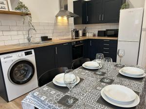 a kitchen with a table with plates and wine glasses at The Old Band Accommodation 1 kingsize bed and 1 Sofa Bed available in Higham Ferrers +5 photos