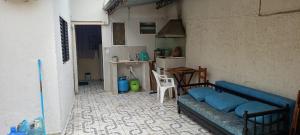 a living room with a blue couch and a kitchen at Casa Vó Amélia in Aparecida