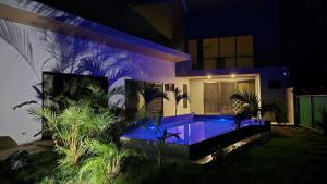 a house at night with a pool in front of it at Villa PRAGA Beach House in Playa Grande