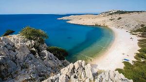 a beach on a rocky hill with blue water at Eola Leisure Rooms in Stara Baška