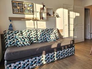 un sofá en la sala de estar con almohadas azules y blancas en Charme Studio 103 Belle Dune, en Fort-Mahon-Plage