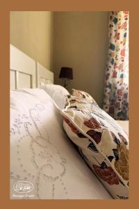 - un lit avec une couette et des oreillers blancs dans l'établissement Rural Holiday home Derdic, à Gornja Zdenčina