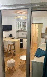a small room with a bedroom and a kitchen with a desk at Studio Chaleureux au Cap d’Agde in Cap d'Agde