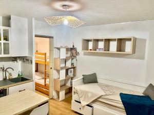a small room with a bed and a kitchen at Studio Chaleureux au Cap d’Agde in Cap d'Agde