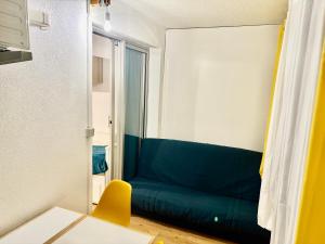 a living room with a green couch and a table at Studio Chaleureux au Cap d’Agde in Cap d'Agde