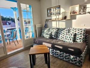 una sala de estar con un sofá y una mesa en Charme Studio 103 Belle Dune, en Fort-Mahon-Plage