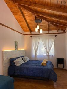a bedroom with a bed with a blue comforter at Viví Bosque in San Carlos de Bariloche