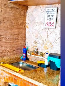 a kitchen sink with a sign that reads keep calm have a lounge at Casa da Praia Costazul in Rio das Ostras