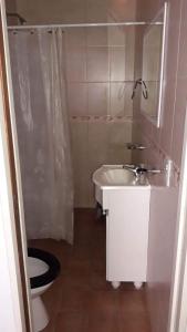 een kleine badkamer met toilet en wastafel bij La posada del Nono in Villa Gesell