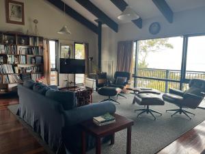 un soggiorno con divano, sedie e TV di Hawkesview a Vincentia