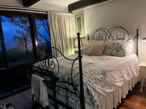 una camera da letto con un letto e una grande finestra di Hawkesview a Vincentia