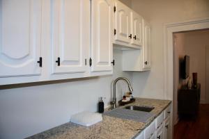 a kitchen with white cabinets and a sink at Wooster Square Gems in New Haven +43 photos