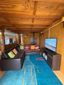 Una sala de estar con un sofá y un televisor de pantalla plana. en Casa con vista a Futaleufú, en Futaleufú