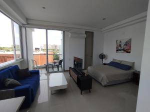 a bedroom with a bed and a couch in a room at Apartaestudio Jacuzzi Centro Comercial Buena vista Restaurantes Gimnasio ALTOPRADO in Barranquilla