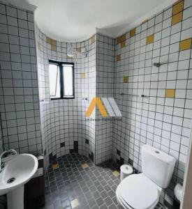 a bathroom with a toilet and a sink at Apartamento enseada in Guarujá
