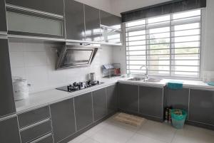 a kitchen with stainless steel cabinets and a sink at D'PrinceDream in Port Dickson