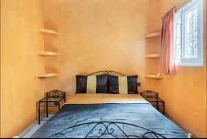 une chambre avec un lit avec deux chaises et une fenêtre dans l'établissement Riad Golden Palm, à Marrakech