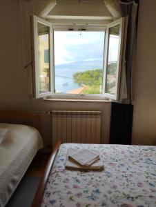 a bedroom with a bed and a window with a tray at Apartments Kat in Splitska