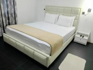 马特莱The Inn At Matale的卧室里有一张大床，床单和枕头都是白色的