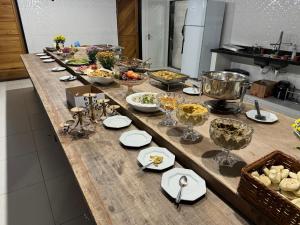 a long buffet of food on a table in a kitchen at Chácara da Acácias in Sao Jose do Rio Preto