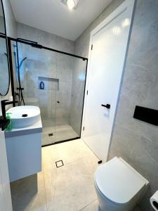 ein Badezimmer mit Dusche, Toilette und Waschbecken in der Unterkunft Brand New Luxury 4 Bedroom House in Marsden Park