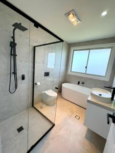 ein Badezimmer mit Dusche, Toilette und Waschbecken in der Unterkunft Brand New Luxury 4 Bedroom House in Marsden Park + 15 Fotos