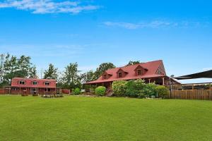 una casa en un patio con césped verde en Hunter Valley Lodge & Retreat - Stunning Country Lodge, en Nulkaba