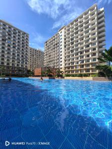 a large swimming pool in front of two large buildings at The Ecru Suite in Lapu Lapu City