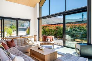 ワナカにあるCoco Chalet by Sotheby's Luxury Rental Homesのソファとテーブルのあるリビングルーム