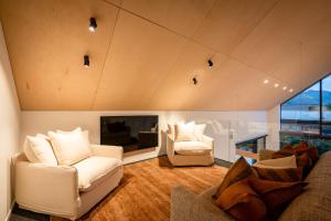 ワナカにあるCoco Chalet by Sotheby's Luxury Rental Homesのリビングルーム(白い椅子2脚、暖炉付)