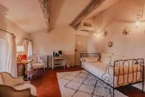 une chambre avec un lit, une table et des chaises dans l'établissement La Maison du Village, à Saint-Rémy-de-Provence