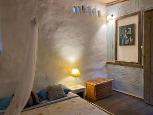 een slaapkamer met een bed en een tafel met een lamp bij Cabaña Iris in La Paloma