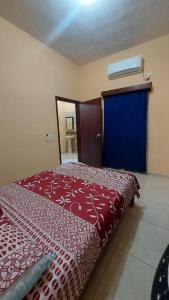 ein Schlafzimmer mit einem roten Bett und einer blauen Tür in der Unterkunft Comfortable apartment in San Blas in San-Blas-Inseln