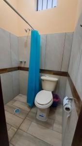 ein Bad mit einem WC und einem blauen Duschvorhang in der Unterkunft Comfortable apartment in San Blas in San-Blas-Inseln