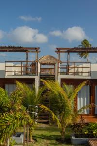 un bâtiment avec des palmiers devant dans l'établissement Chalé Carnaúba by Breezy Sport House, à Tutóia 12 autres photos